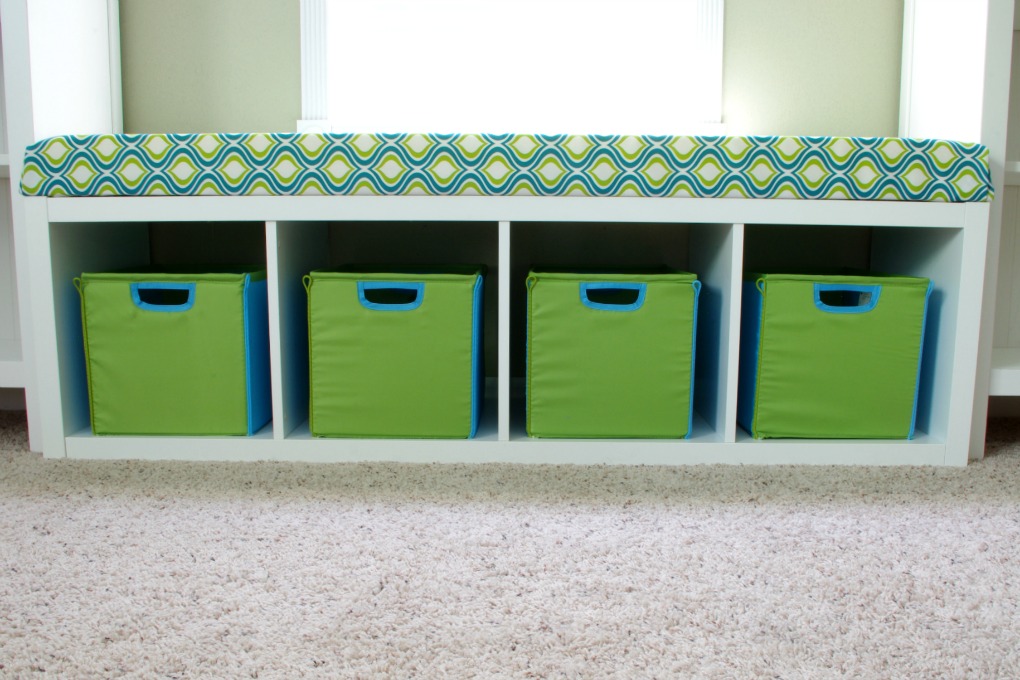 We created a fun bench seat in our playroom using an IKEA Kallax shelf unit. It is the perfect place for kids to sit and read a book! | #organization #organizing #storage #storagebins #organized #kallax #playroom
